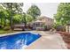 Beautiful backyard features an in-ground pool, lush landscaping, and a sunroom at 8214 Coristar Pl, Huntersville, NC 28078