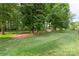 Expansive backyard featuring lush green grass, mature trees, and a wooden fence, offering ample space for outdoor activities at 8214 Coristar Pl, Huntersville, NC 28078