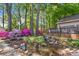 A tranquil backyard with lush landscaping, a small waterfall, and vibrant azaleas at 8214 Coristar Pl, Huntersville, NC 28078