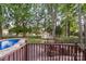 Picturesque backyard view features a pool, shed, mature trees, and a wooden deck at 8214 Coristar Pl, Huntersville, NC 28078