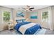 Stylish bedroom bathed in natural light, featuring a ceiling fan and unique coastal artwork at 8214 Coristar Pl, Huntersville, NC 28078