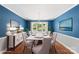 Dining room boasts blue walls, hardwood floors, traditional furnishings, and ample natural light at 8214 Coristar Pl, Huntersville, NC 28078