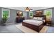 Comfortable main bedroom featuring a ceiling fan, plush rug, and natural light from several windows at 8214 Coristar Pl, Huntersville, NC 28078