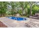 Sparkling in-ground pool surrounded by mature trees and lounge chairs, perfect for relaxation at 8214 Coristar Pl, Huntersville, NC 28078