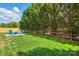 Expansive backyard features lush green grass, a fire pit with blue Adirondack chairs, and a classic wooden fence at 8726 Castle Cliff Dr, Matthews, NC 28105