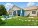 Spacious backyard featuring blue Adirondack chairs around a fire pit and covered patio with blue curtains at 8726 Castle Cliff Dr, Matthews, NC 28105