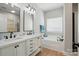 Bright bathroom with double vanity, white cabinets, black fixtures, and separate bathtub at 8726 Castle Cliff Dr, Matthews, NC 28105
