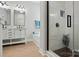 Well-lit bathroom with a double vanity, black fixtures, a bathtub, and a modern glass shower at 8726 Castle Cliff Dr, Matthews, NC 28105