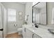 Well-lit bathroom with a white vanity, modern black fixtures, and a framed mirror over the sink at 8726 Castle Cliff Dr, Matthews, NC 28105