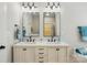 Bathroom featuring a dual sink vanity with elegant black fixtures, mirrors, and bright lighting at 8726 Castle Cliff Dr, Matthews, NC 28105