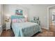 Comfortable bedroom with a plush blue headboard, decorative pillows, and a vintage-style vanity at 8726 Castle Cliff Dr, Matthews, NC 28105