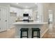 Modern kitchen with white quartz countertops, stainless steel appliances, and a breakfast bar with stools at 8726 Castle Cliff Dr, Matthews, NC 28105