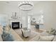 Bright, open-concept living room with a cozy fireplace, modern chandelier, and seamless flow to the kitchen at 8726 Castle Cliff Dr, Matthews, NC 28105