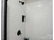 Modern bathroom shower with black hardware, bright white tile and a built-in niche at 8726 Castle Cliff Dr, Matthews, NC 28105