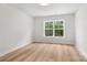 Simple bedroom featuring light wood floors, neutral walls, and a bright sunny window at 925 Twin Lakes Rd, Rock Hill, SC 29732