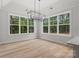Bright dining room with a modern chandelier and expansive windows offering a serene view of the surrounding landscape at 925 Twin Lakes Rd, Rock Hill, SC 29732