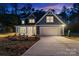 Charming home with a manicured lawn, a two-car garage, and a cozy front porch, illuminated against a twilight sky at 925 Twin Lakes Rd, Rock Hill, SC 29732