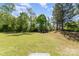 Large grassy backyard with mature trees and shrubs, perfect for outdoor relaxation at 9527 Turning Wheel Dr, Charlotte, NC 28214