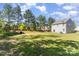 Beautiful backyard with mature trees and a well-maintained lawn, offering privacy at 9527 Turning Wheel Dr, Charlotte, NC 28214