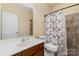 Cozy bathroom with a toilet, shower featuring tiled walls, and a vanity sink at 9527 Turning Wheel Dr, Charlotte, NC 28214