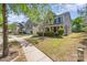 A charming two-story home with stone accents and a well-maintained lawn on a sunny day at 9527 Turning Wheel Dr, Charlotte, NC 28214