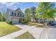 A well-manicured lawn leads to a two-story home with an attached garage and lengthy driveway at 9527 Turning Wheel Dr, Charlotte, NC 28214