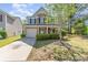 Charming two-story home with stone accents, a covered porch and lush landscaping at 9527 Turning Wheel Dr, Charlotte, NC 28214