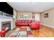 Warm living room with fireplace, hardwood floors and an inviting red sectional sofa at 9527 Turning Wheel Dr, Charlotte, NC 28214