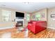 Cozy living room with a fireplace, hardwood floors, and a comfortable red leather sofa at 9527 Turning Wheel Dr, Charlotte, NC 28214