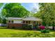 Charming brick home featuring a well-manicured lawn and colorful, mature landscaping at 105 Hopper St, Clover, SC 29710