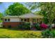 Charming brick home featuring a well-manicured lawn and colorful, mature landscaping at 105 Hopper St, Clover, SC 29710