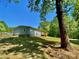 Exterior view showing a light blue house with a wood deck nestled in a wooded landscape at 109 Bee Tree Ln, Salisbury, NC 28144