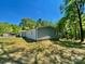 Back exterior of the house with a light blue siding, a wood deck, and green lawn surrounded by trees at 109 Bee Tree Ln, Salisbury, NC 28144