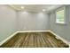 Minimalist bedroom featuring gray walls, wood floors, and a bright window with natural light at 109 Bee Tree Ln, Salisbury, NC 28144