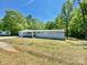 Charming home featuring a concrete driveway, and light blue siding nestled in a wooded landscape at 109 Bee Tree Ln, Salisbury, NC 28144