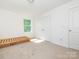 A clean, bright bedroom with an empty bed frame, white walls, and ample natural light at 11010 Redcoat Hill Ln # 33, Huntersville, NC 28078