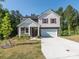 Charming two-story home with a well-manicured lawn, showcasing its inviting front porch, two-car garage, and modern facade at 11010 Redcoat Hill Ln # 33, Huntersville, NC 28078