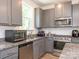 Functional kitchen with gray cabinetry, stone countertops, and stainless appliances at 11010 Redcoat Hill Ln # 33, Huntersville, NC 28078