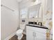 Bathroom with toilet, vanity with black countertop, mirror, and shower with flower curtain at 1115 Greenleaf Ave # B, Charlotte, NC 28202