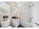 Bathroom with toilet, vanity with black countertop, mirror, and shower with flower curtain at 1115 Greenleaf Ave # B, Charlotte, NC 28202