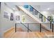 Modern staircase with wood treads, black metal railing, natural light, and artwork at 1115 Greenleaf Ave # B, Charlotte, NC 28202