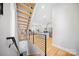 Modern staircase with wood treads, black metal railing, and open floor plan at 1115 Greenleaf Ave # B, Charlotte, NC 28202