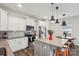 Bright kitchen features white cabinets, stainless appliances, granite counters and center island with pendant lights at 1218 Juddson Dr, Waxhaw, NC 28173