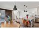 Open-concept space with barn door, stairs, dining area with industrial pendant lights and kitchen with island at 1218 Juddson Dr, Waxhaw, NC 28173