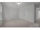 Bright bedroom featuring neutral carpet, crisp white walls, double door closet, and access to additional storage at 124 Canary Ln # 7, Mooresville, NC 28115