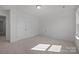Spacious bedroom featuring neutral carpet, crisp white walls, a double door closet, and ample natural light at 124 Canary Ln # 7, Mooresville, NC 28115