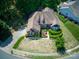 Aerial shot of a brick home with a driveway and well-kept lawn in a residential area at 13316 Alex Mill Dr, Pineville, NC 28134