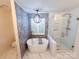 Updated bathroom featuring a soaking tub, glass shower, and modern fixtures at 13316 Alex Mill Dr, Pineville, NC 28134