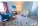 Cozy Bedroom featuring a rocking chair, crib, and a changing table, all set on a patterned rug at 13316 Alex Mill Dr, Pineville, NC 28134