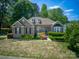 Charming single-Gathering home with a brick facade, dormer windows, and lush landscaping at 13316 Alex Mill Dr, Pineville, NC 28134